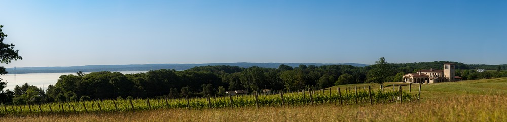 Panorama of the winery building overlooking East Grand Traverse Bay with the vineyards in the foreground